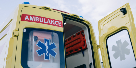 The back of a yellow ambulance is seen with the right door open.