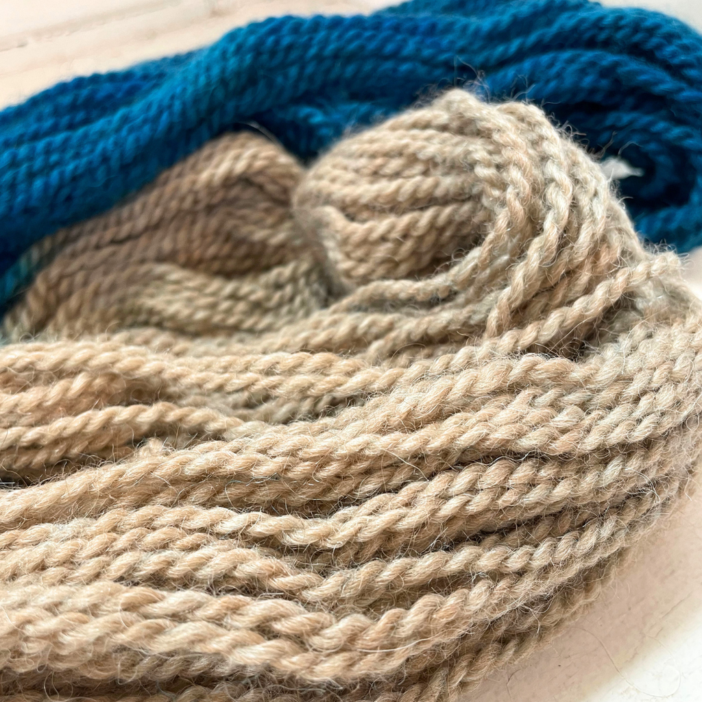 up close view of hand dyed blue and fawn alpaca yarn